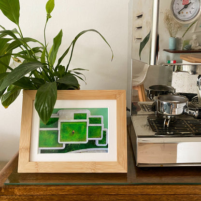 Nachhaltiger Holz Bilderrahmen Ecofray Classic mit einer Drohnenaufnahme vor einer Kaffeemaschine und einer Pflanze